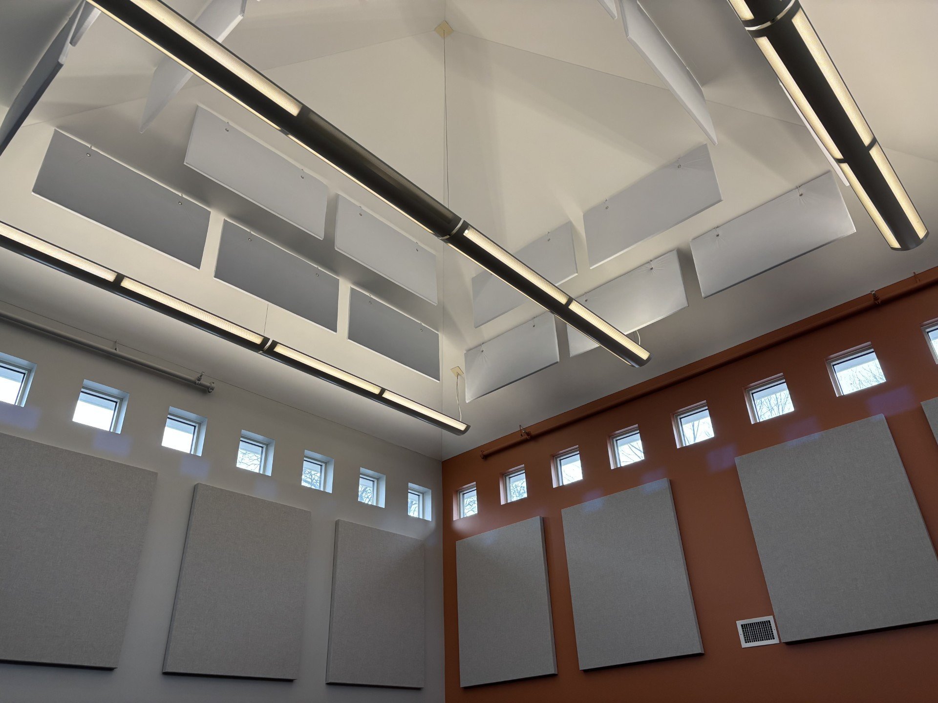 The Goddard School of Framingham playroom after acoustic treatment, with fabric-wrapped wall panels and white ceiling baffles