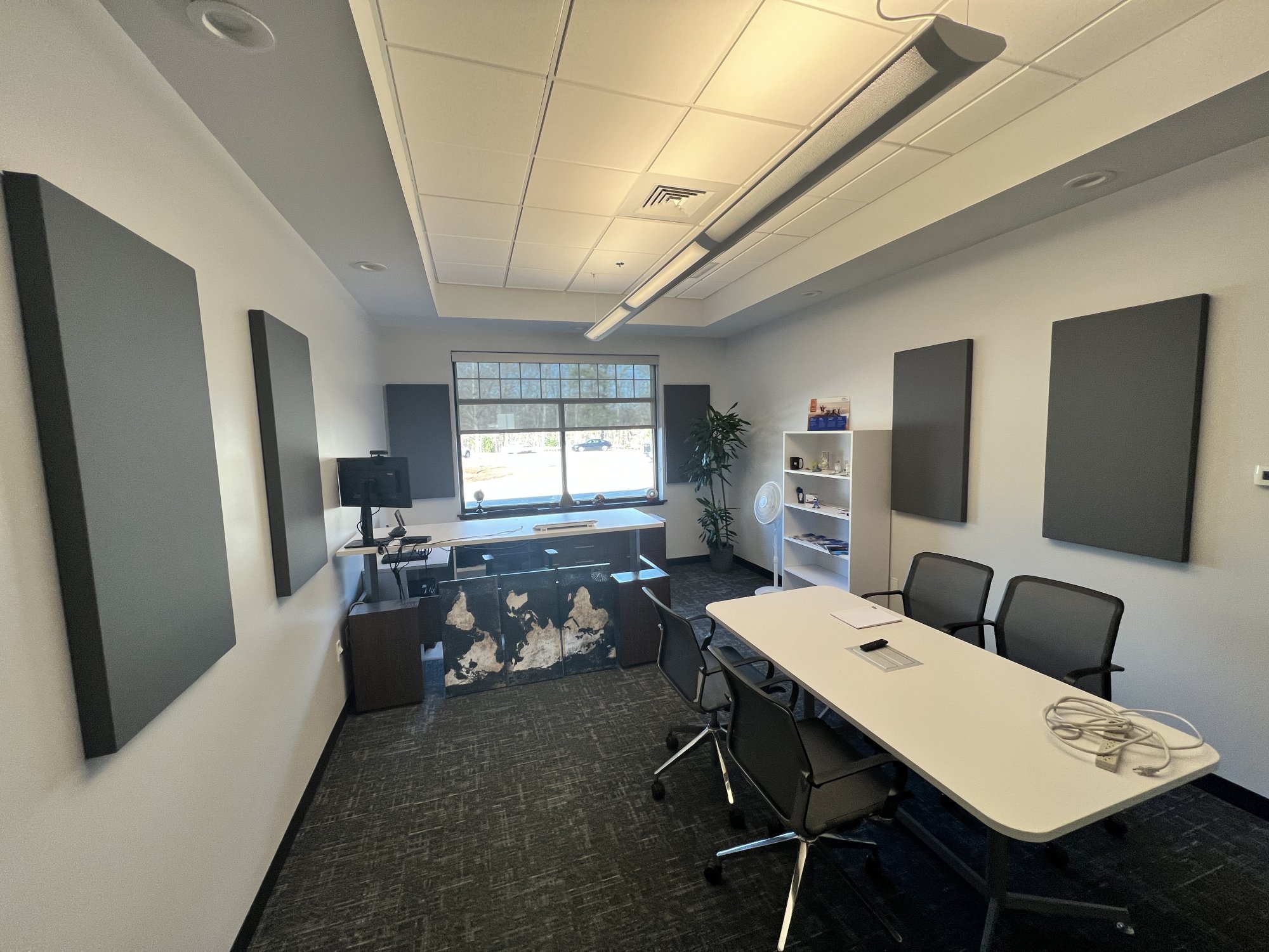 Lenze America executive office in Uxbridge, MA after acoustic treatment, with gray fabric-wrapped wall panels distributed around the room